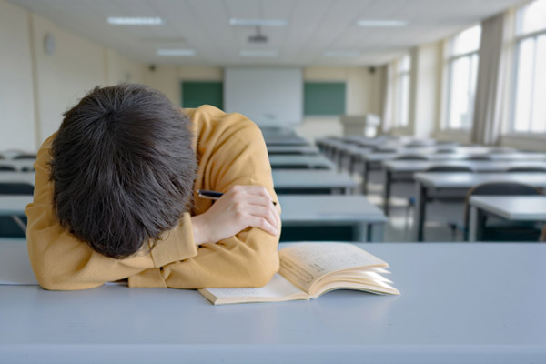 教室の片隅、学校に楽しみを見いだせず、一人でたたずむ