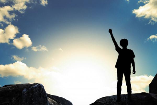 晴れ渡った空を背景にガッツポーズをしている画像。未来をつかみ取るイメージを想起していただきたいための画像。