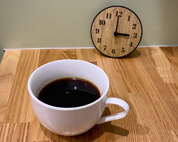 テーブルに置かれたコーヒーと時計。場所や時間の区切り方を柔軟に工夫して、無理なく勉強に取り組むイメージ。